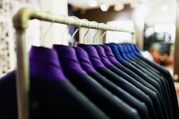 Row of suits hanging on rack in clothing store